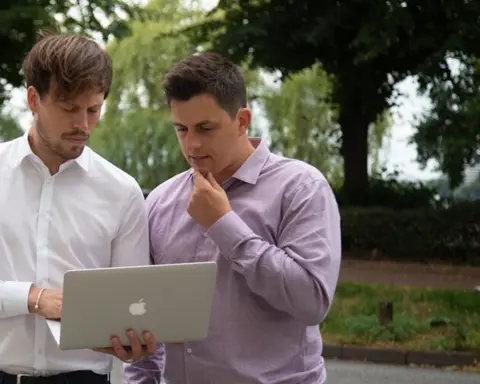Jakob und Anselm Schilk besprechen eine Immobilienfinanzierung am Laptop
